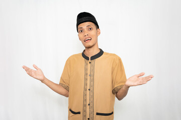 Muslim Asian man wearing brown Muslim shirt feeling confused or not knowing. Isolated white...