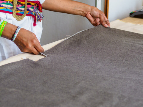 black african seamstress artisan tailor measure mark cut sew fabric on desk in the fashion workshop