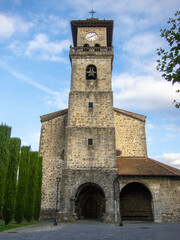 Main façade of the medieval gothic church of Santa María in Amurrio with its large stone tower and clock in the Basque Country.