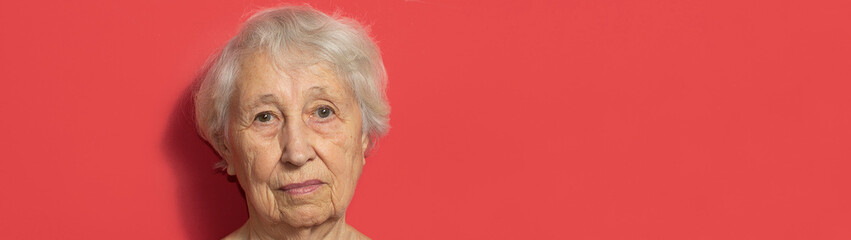 Close up portrait of senior woman against red background