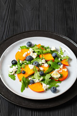 arugula persimmon cheese berries salad, top view