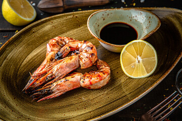 Grilled king prawns with soy sauce. Menu for a restaurant. Beautiful composition on wooden boards.