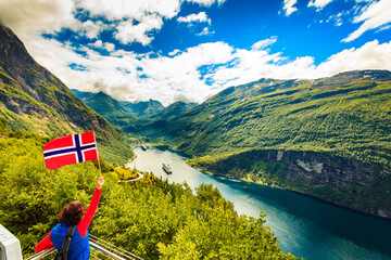 Tourist over Geirangerfjord with norwegian flag