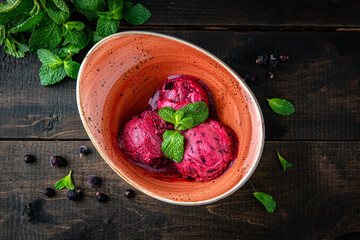 Ice cream berry sorbet made from blackcurrant and mint. Menu for a restaurant. Beautiful composition on wooden boards.