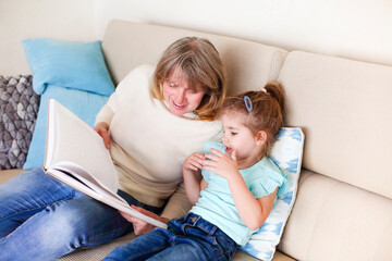 Granny and little girl reading book together