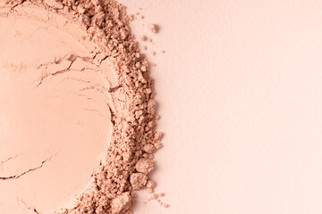 Loose powder for makeup in a natural beige color. Powder texture, cosmetic peach background with...