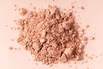 Loose powder for makeup in a natural beige color. Powder texture, cosmetic peach background with copy space.