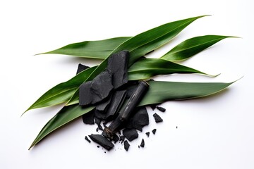 Top view of isolated activated charcoal with bamboo leaf on white background