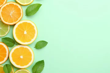 Foto op Canvas Top view of lemon and orange refreshment on retro mint pastel background with copyspace © VolumeThings