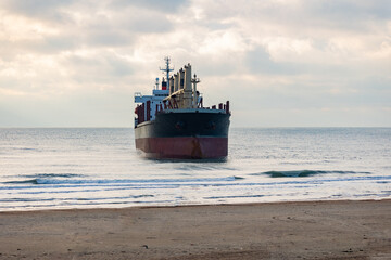 Naklejka na ściany i meble A large cargo sea ship sails on the ocean among the waves