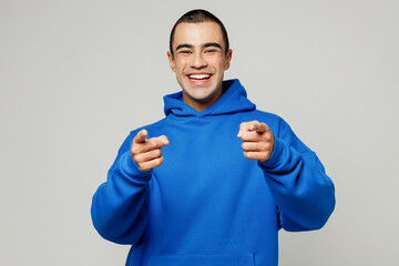 Young smiling happy middle eastern man he wear blue hoody casual clothes point index fingers camera...