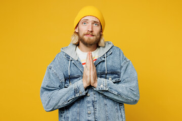 Young blond man he wear denim shirt hoody beanie hat casual clothes hold hands folded in prayer...
