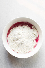 Beet Focaccia dough in a white bowl, process of making pink focaccia, beet dough rising in a white mixing bowl