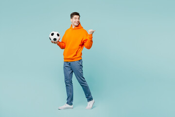 Full body excited young man he wears orange hoody casual clothes do winner gesture clench fist look...