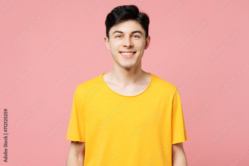 Wall mural Young smiling happy cheerful fun cool Caucasian man he wears yellow t-shirt casual clothes looking camera isolated on plain pastel light pink color wall background studio portrait. Lifestyle concept.