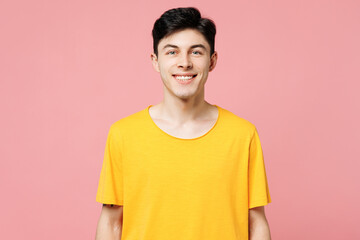 Young smiling happy cheerful fun cool Caucasian man he wears yellow t-shirt casual clothes looking camera isolated on plain pastel light pink color wall background studio portrait. Lifestyle concept.