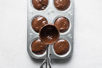 chocolate muffin batter in a cookie scoop, process of making chocolate muffin