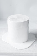 Process of covering a round cake with fondant, paneling a Styrofoam cake dummy with fondant icing
