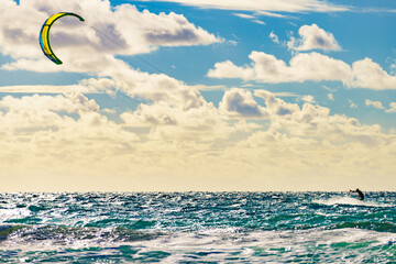 Kite surfer riding waves. Kiteboarding sport.