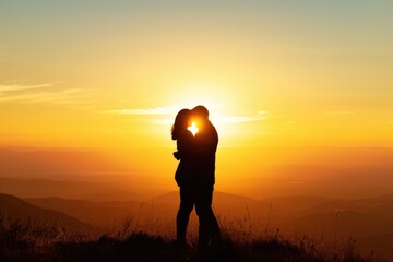 Silhouette of a couple embracing on a hilltop, with a breathtaking view of the valley below during sunset