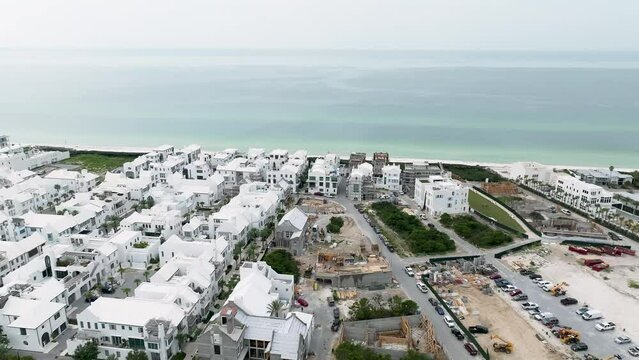 spin motion view of Alys beach white houses, Ocean side on the background, some houses under construction and cars on the right side parking lot, (Construction site)