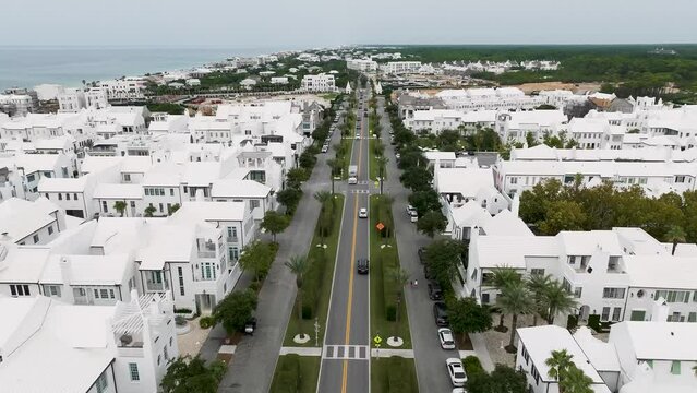 straight up motion over Hwy 30A in Alys Beach FL with active traffic movement and ocean on the background left