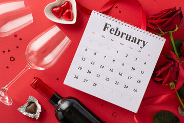 Love is near: Top view of February calendar, chocolate treats, wine bottle, glasses, roses, silk...