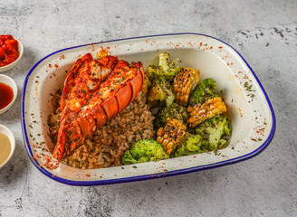 grilled lobster tail with fried rice, grilled corn and broccoli served in isolated on grey background top view of singaporean food