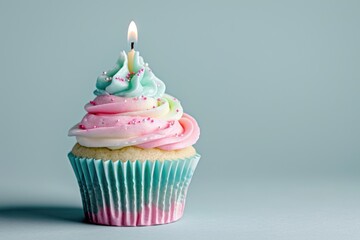 Light pink and light blue cupcake with one candle