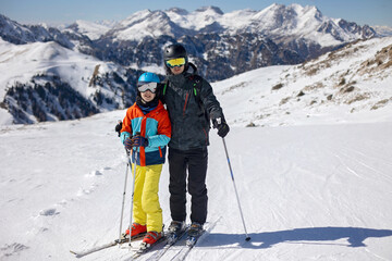 Happy family, enjoying ski holiday with children, sunny beautiful weather