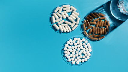 Various vitamins, tablets and dietary supplements on a blue background. Medicine. Copy space