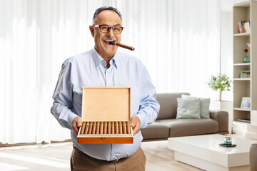 Mature man smoking a cigar at home