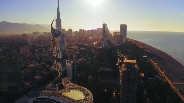 Aerial view of Batumi city panorama downtown at sunset. Flying on drone above old town roofs and modern high buildings. Famous international Georgian black sea resort.
