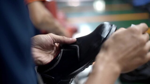 Hand meticulously applies shoe shiner to a shoe making it shine