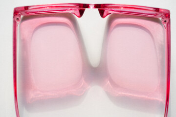 Pink sunglasses shadows on white background. Top view summer modern background copy paste