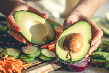 Close-up of a cut avocado in a woman's hands.