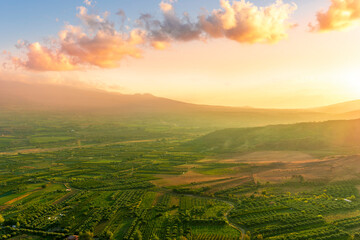rustic landscape view of rural green valley in mountain hills with farms and gardens