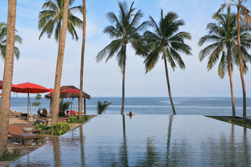 Beach pavilion with red roofs, palm trees