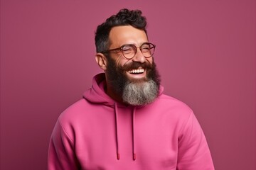 Fototapeta premium Portrait of a cheerful bearded man in pink hoodie and glasses.