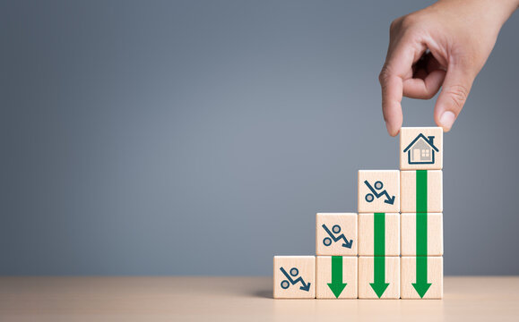 Interest rate decline, low rental prices. Percentage sign with green arrow going down on wooden cubes. Real estate property investment concept. Reducing of load interest rates payment, mortgage rate.