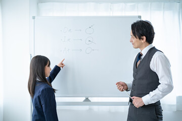 黒板を使い勉強を教える先生と生徒