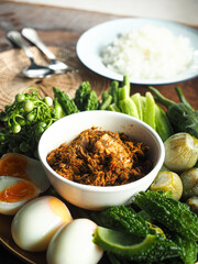 Kua Gling Pla, Thai southern stir fried fish meat with yellow curry paste, served with boiled egg and fresh vegetables and steamed rice