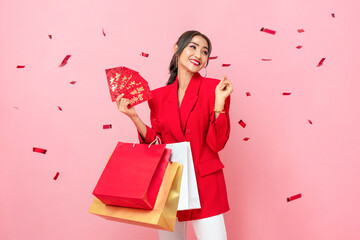 Happy beautiful Asian woman with Ang Pao envelopes and shopping bags for Chinese new year sale...