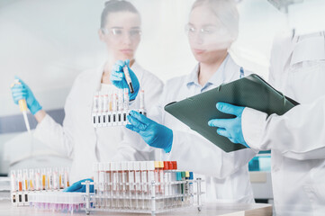  team of three scientists works in secure laboratory with high level of danger behind glass. Series of experiments and analyzes with test tubes and pipettes. new studies of women scientists