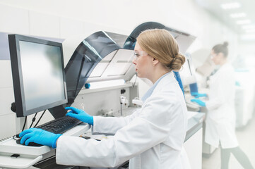 A female scientific researcher conducts a series of experiments in a modern bio laboratory with test tubes and a pipette. Laboratory assistant working on computer