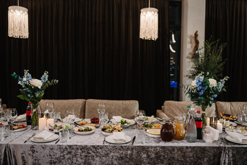 Food and drink on the dining table. Plate and glass, luxury rich decor. Wedding set up, dinner table reception in a restaurant. Serving, setting table in the hall. Birthday, baptism, event.