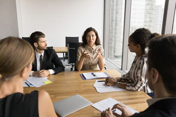 Middle aged business professional offering ideas for project management, work strategy. Diverse...