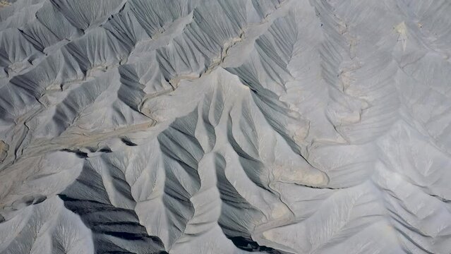 Mudstone formations of steel blue wavy sharp rocks ridges western Usa. Factory Butte canyon towering of wonder foothills. Aerial view over rugged terrain structure carved riverbed by erosion