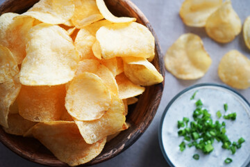 Potato chips with sauce with herbs on a gray background