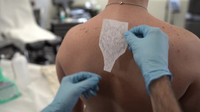 Toma detalle colocando calco de tatuaje a persona